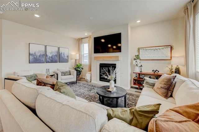 10806 Rolling Peaks Dr, Peyton, CO 80831 - living area with wood finished floors, a glass covered fireplace, recessed lighting, and baseboards