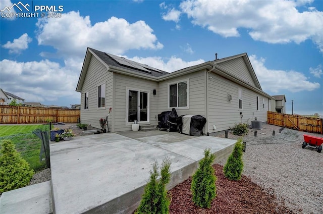 10806 Rolling Peaks Dr, Peyton, CO 80831 - rear view of property featuring roof mounted solar panels, a patio, a fenced backyard, and cooling unit