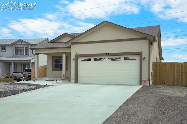 5228 Gannet Ln, Pueblo, CO 81008 - ranch-style home featuring an attached garage, stucco siding, driveway, and roof with shingles
