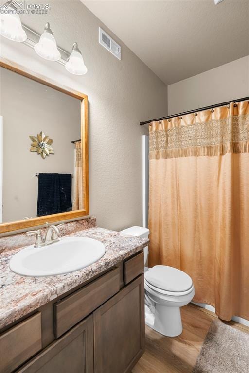 5228 Gannet Ln, Pueblo, CO 81008 - full bathroom with wood finished floors, vanity, and a shower with shower curtain
