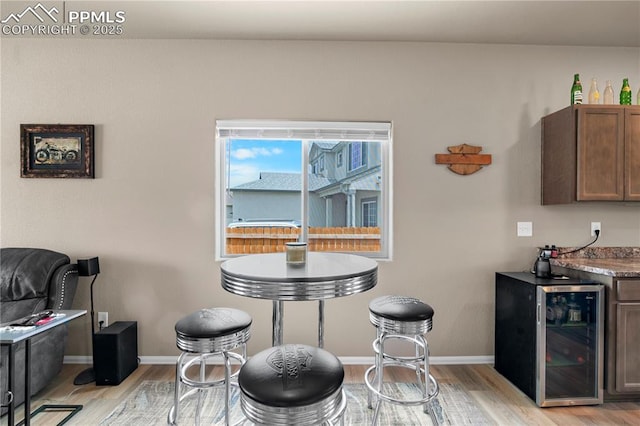 5228 Gannet Ln, Pueblo, CO 81008 - dining area with beverage cooler, light wood-style flooring, and bar