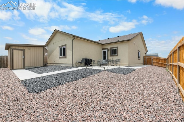 5228 Gannet Ln, Pueblo, CO 81008 - back of house with stucco siding, a fenced backyard, a patio area, and a storage shed