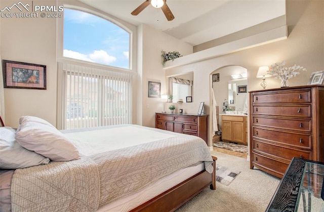 2582 Indian Hills Grv, Colorado Springs, CO 80907 - bedroom with arched walkways, light colored carpet, connected bathroom, a ceiling fan, and high vaulted ceiling