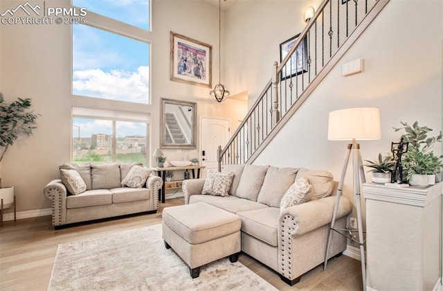 2582 Indian Hills Grv, Colorado Springs, CO 80907 - living area with a towering ceiling, wood finished floors, baseboards, and stairway