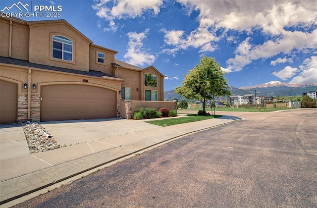 2582 Indian Hills Grv, Colorado Springs, CO 80907 - view of front of home featuring a mountain view, stucco siding, driveway, and an attached garage