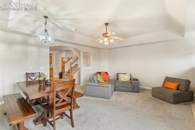 2237 Stepping Stones Way Unit C, Colorado Springs, CO 80904 - dining room featuring arched walkways, a raised ceiling, light colored carpet, ceiling fan, and baseboards