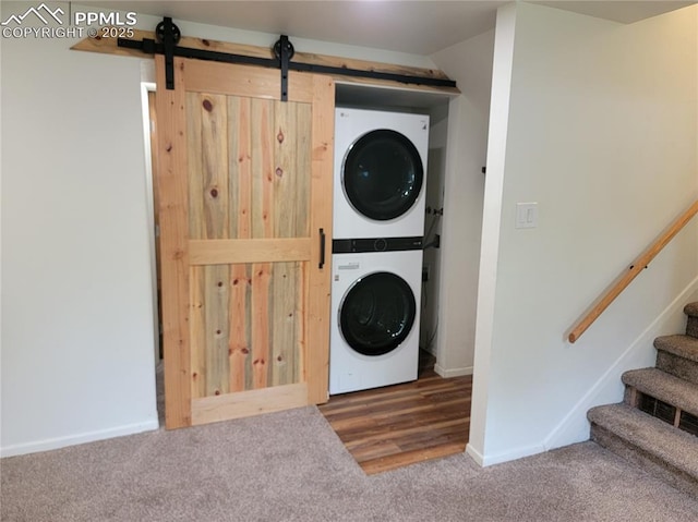 2619 N Arcadia St, Colorado Springs, CO 80907 - laundry area with estacked washer and dryer, carpet flooring, baseboards, and a barn door