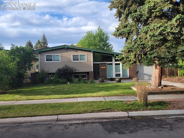 2619 N Arcadia St, Colorado Springs, CO 80907 - split level home with a garage, a front yard, and brick siding