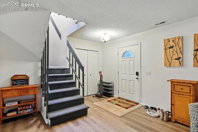 4840 Pikes Peak Hwy, Cascade, CO 80809 - foyer entrance featuring wood finished floors, a textured ceiling, and stairway