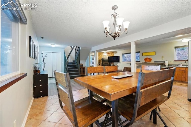 4840 Pikes Peak Hwy, Cascade, CO 80809 - dining space featuring light tile patterned floors, a textured ceiling, stairs, baseboards, and a chandelier