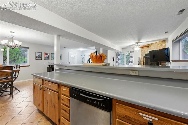 4840 Pikes Peak Hwy, Cascade, CO 80809 - kitchen featuring stainless steel dishwasher, a textured ceiling, brown cabinets, light tile patterned floors, and healthy amount of natural light