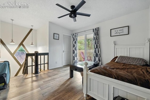 4840 Pikes Peak Hwy, Cascade, CO 80809 - bedroom featuring a textured ceiling, wood finished floors, access to outside, and ceiling fan
