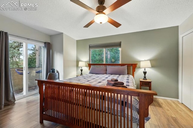 4840 Pikes Peak Hwy, Cascade, CO 80809 - bedroom with access to exterior, multiple windows, wood finished floors, a textured ceiling, and baseboards