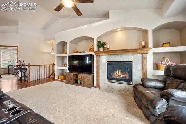 20280 Melanie Ann Ct, Monument, CO 80132 - carpeted living area featuring a ceiling fan, vaulted ceiling, built in features, and a fireplace
