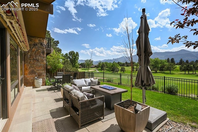 3320 Camels Ridge Ln, Colorado Springs, CO 80904 - fenced backyard featuring a mountain view, an outdoor living space with a fire pit, a patio, and outdoor dining space