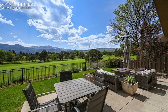 3320 Camels Ridge Ln, Colorado Springs, CO 80904 - fenced backyard featuring a mountain view, a patio, and an outdoor living space with a fire pit