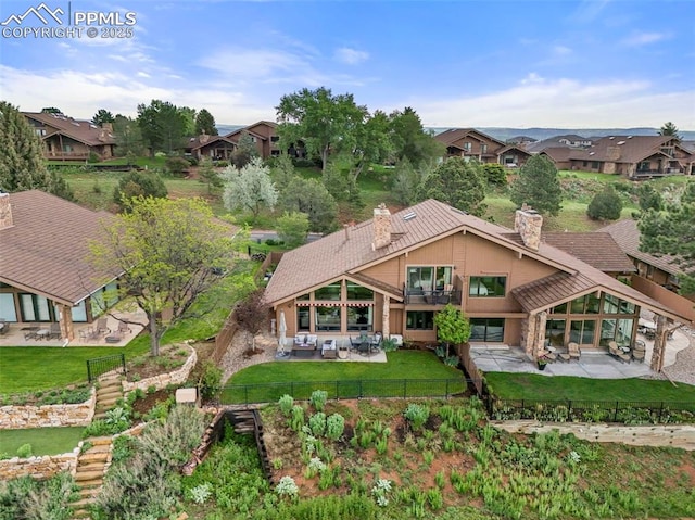 3320 Camels Ridge Ln, Colorado Springs, CO 80904 - view of front facade featuring a chimney, a patio, a fenced backyard, and a residential view