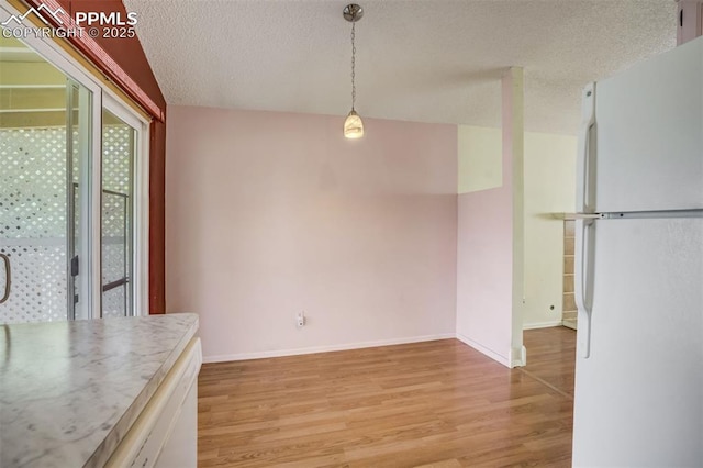 6430 Chantilly Pl, Colorado Springs, CO 80922 - unfurnished dining area with a textured ceiling and light wood-type flooring
