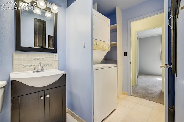 6430 Chantilly Pl, Colorado Springs, CO 80922 - bathroom featuring stacked washer and clothes dryer, tasteful backsplash, vanity, and tile patterned floors