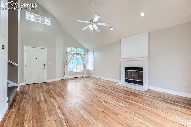 9412 Dew Drop Ct, Colorado Springs, CO 80925 - unfurnished living room with high vaulted ceiling, wood finished floors, a ceiling fan, a fireplace, and baseboards