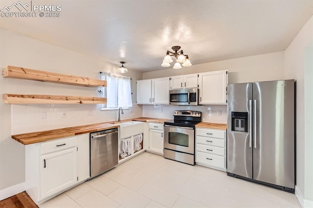 9412 Dew Drop Ct, Colorado Springs, CO 80925 - kitchen featuring appliances with stainless steel finishes, butcher block countertops, a sink, and tasteful backsplash