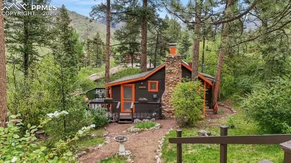 6015 Sioux Trl, Cascade, CO 80809 - rear view of house featuring a deck and a chimney