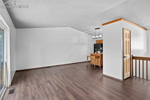 527 W Columbia St, Colorado Springs, CO 80907 - unfurnished living room featuring a textured ceiling, dark wood-style flooring, lofted ceiling, a chandelier, and baseboards