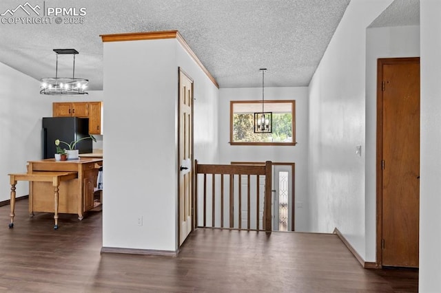 527 W Columbia St, Colorado Springs, CO 80907 - foyer with a chandelier, a textured ceiling, dark wood-type flooring, and baseboards