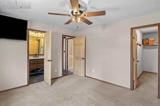 527 W Columbia St, Colorado Springs, CO 80907 - unfurnished bedroom with light colored carpet, a spacious closet, baseboards, connected bathroom, and a sink