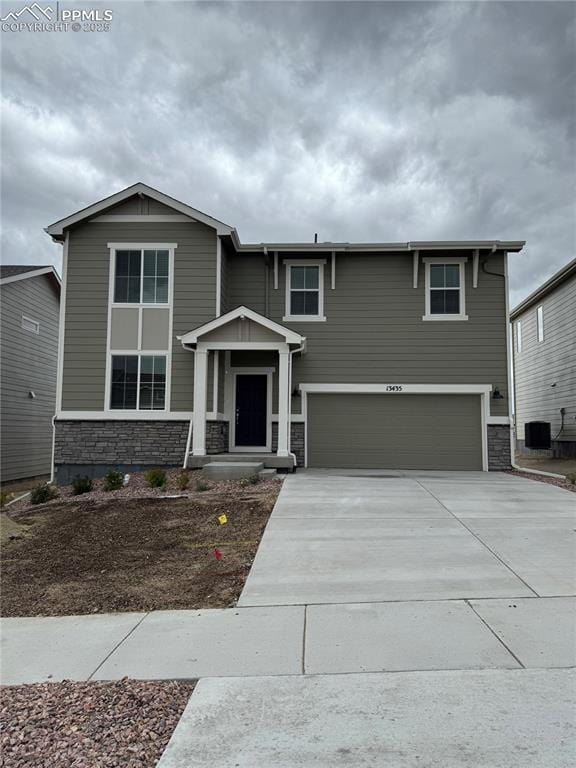 13435 Valley Peak Dr, Peyton, CO 80831 - view of front of home featuring stone siding, a garage, and driveway