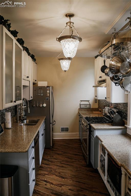817 Swope Ave, Colorado Springs, CO 80909 - kitchen with gas range, dark wood-style flooring, tasteful backsplash, and extractor fan