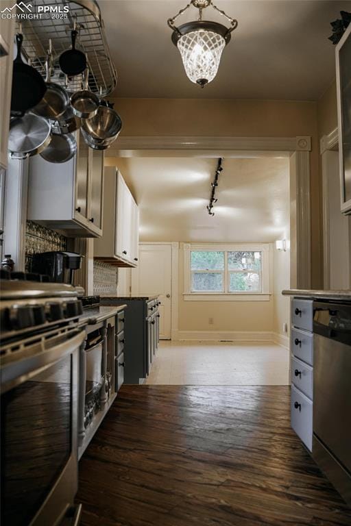 817 Swope Ave, Colorado Springs, CO 80909 - kitchen featuring appliances with stainless steel finishes, rail lighting, a chandelier, and light wood-type flooring