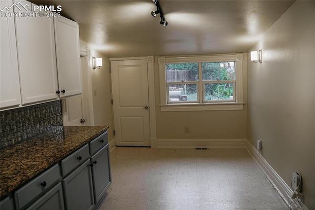 817 Swope Ave, Colorado Springs, CO 80909 - kitchen with dark stone countertops, track lighting, white cabinetry, and gray cabinetry