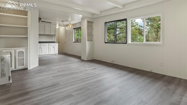 900 Beaver Creek Dr, Florissant, CO 80816 - unfurnished living room featuring wood finished floors, beamed ceiling, and heating unit