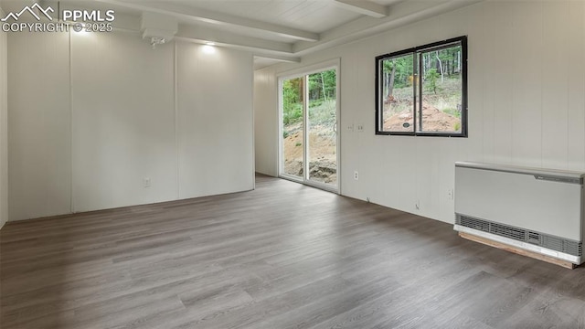 900 Beaver Creek Dr, Florissant, CO 80816 - empty room with heating unit, wood finished floors, and beam ceiling
