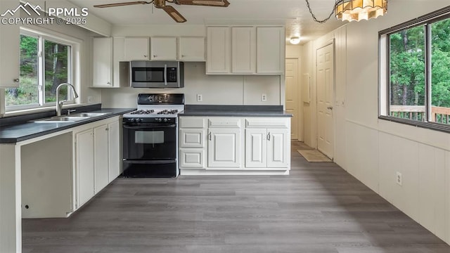 900 Beaver Creek Dr, Florissant, CO 80816 - kitchen featuring stainless steel microwave, gas stove, dark countertops, a sink, and ceiling fan