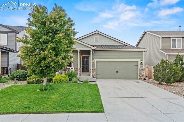 10067 Seawolf Dr, Colorado Springs, CO 80925 - view of front facade featuring an attached garage, driveway, and stone siding