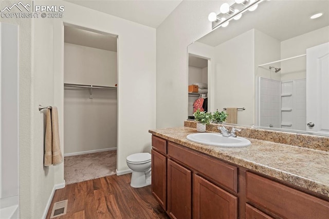 10067 Seawolf Dr, Colorado Springs, CO 80925 - full bath with a walk in closet, vanity, toilet, wood finished floors, and baseboards