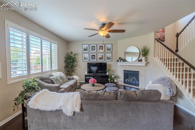 7312 Grady Cir, Castle Rock, CO 80108 - living area with stairs, baseboards, dark wood-style floors, a tiled fireplace, and ceiling fan