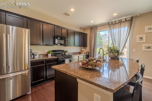 7312 Grady Cir, Castle Rock, CO 80108 - kitchen with freestanding refrigerator, range with gas stovetop, black microwave, stone countertops, and dark wood finished floors
