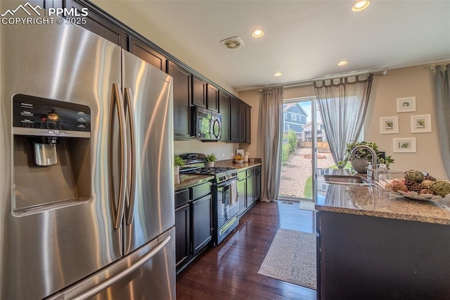 7312 Grady Cir, Castle Rock, CO 80108 - kitchen featuring stainless steel fridge with ice dispenser, range with gas stovetop, black microwave, a sink, and stone counters