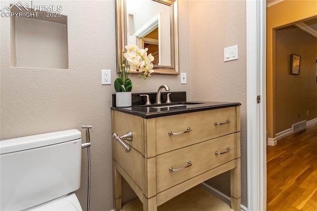 1017 N Sheridan Ave, Colorado Springs, CO 80909 - bathroom with wood finished floors, vanity, and toilet