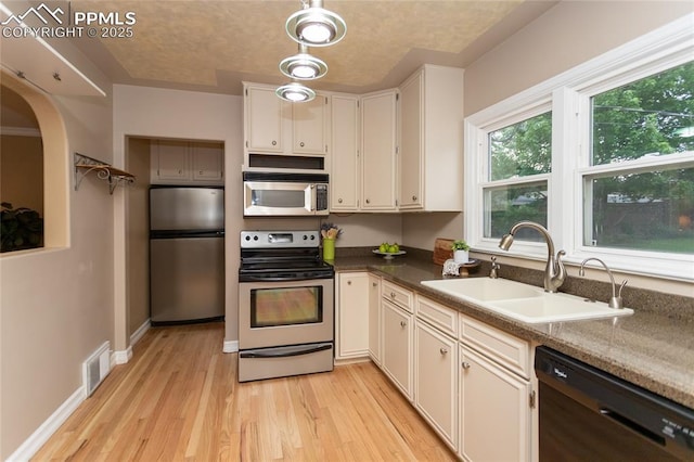 1017 N Sheridan Ave, Colorado Springs, CO 80909 - kitchen with appliances with stainless steel finishes, a sink, light wood-style flooring, white cabinets, and baseboards