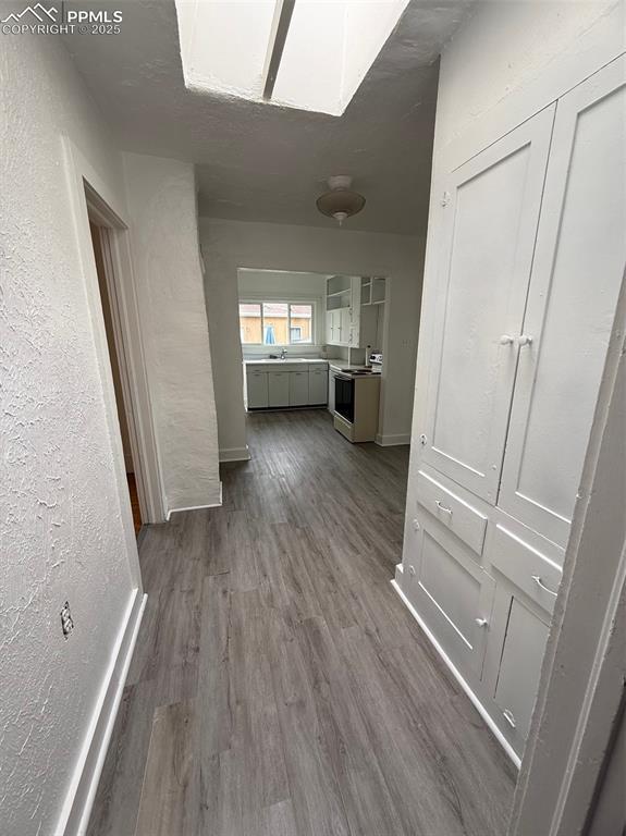 506 S Hancock Ave, Colorado Springs, CO 80903 - hallway featuring dark wood-style flooring, a textured wall, and baseboards