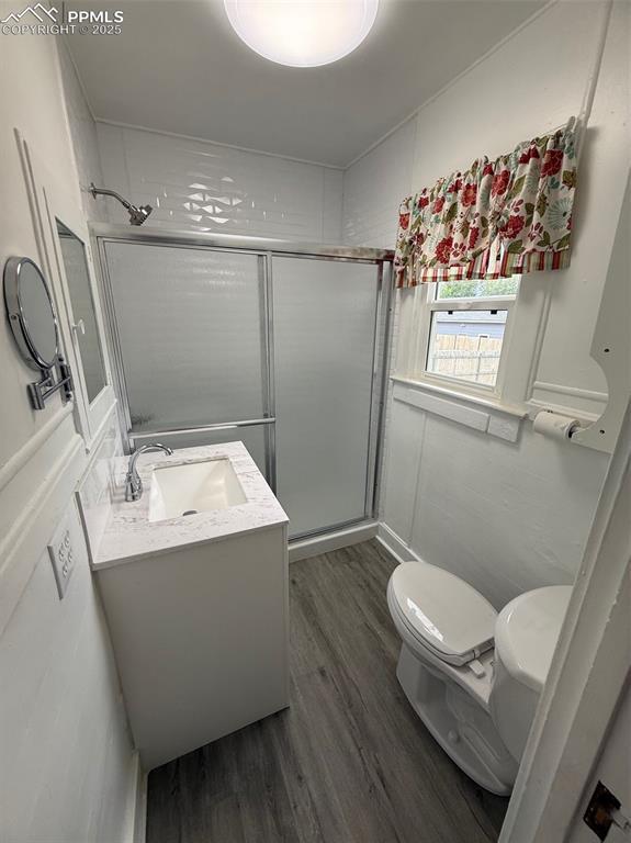 506 S Hancock Ave, Colorado Springs, CO 80903 - full bathroom with toilet, vanity, wood finished floors, and a shower stall