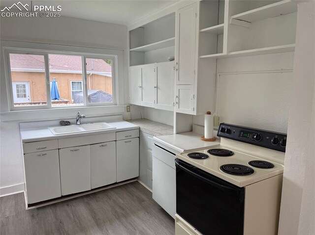 506 S Hancock Ave, Colorado Springs, CO 80903 - kitchen with electric range, open shelves, wood finished floors, white cabinets, and a sink