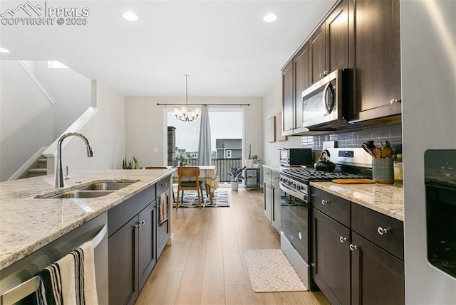 6697 Cool Breeze Dr, Colorado Springs, CO 80923 - kitchen with appliances with stainless steel finishes, dark brown cabinetry, a chandelier, tasteful backsplash, and recessed lighting
