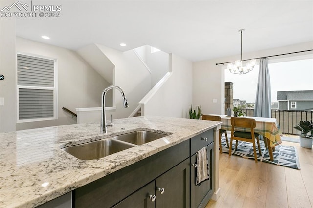 6697 Cool Breeze Dr, Colorado Springs, CO 80923 - kitchen featuring light wood-style flooring, pendant lighting, a chandelier, light stone countertops, and recessed lighting
