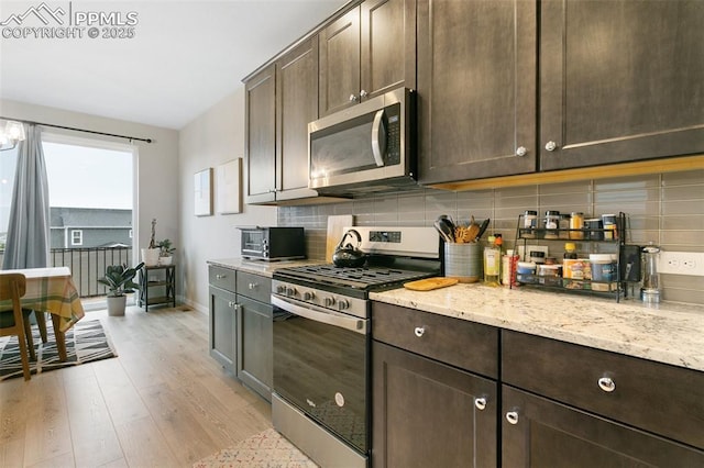 6697 Cool Breeze Dr, Colorado Springs, CO 80923 - kitchen featuring appliances with stainless steel finishes, light wood-style floors, and dark brown cabinets
