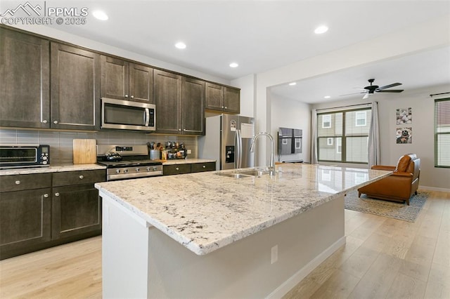 6697 Cool Breeze Dr, Colorado Springs, CO 80923 - kitchen with appliances with stainless steel finishes, light wood-style floors, dark brown cabinets, decorative backsplash, and recessed lighting
